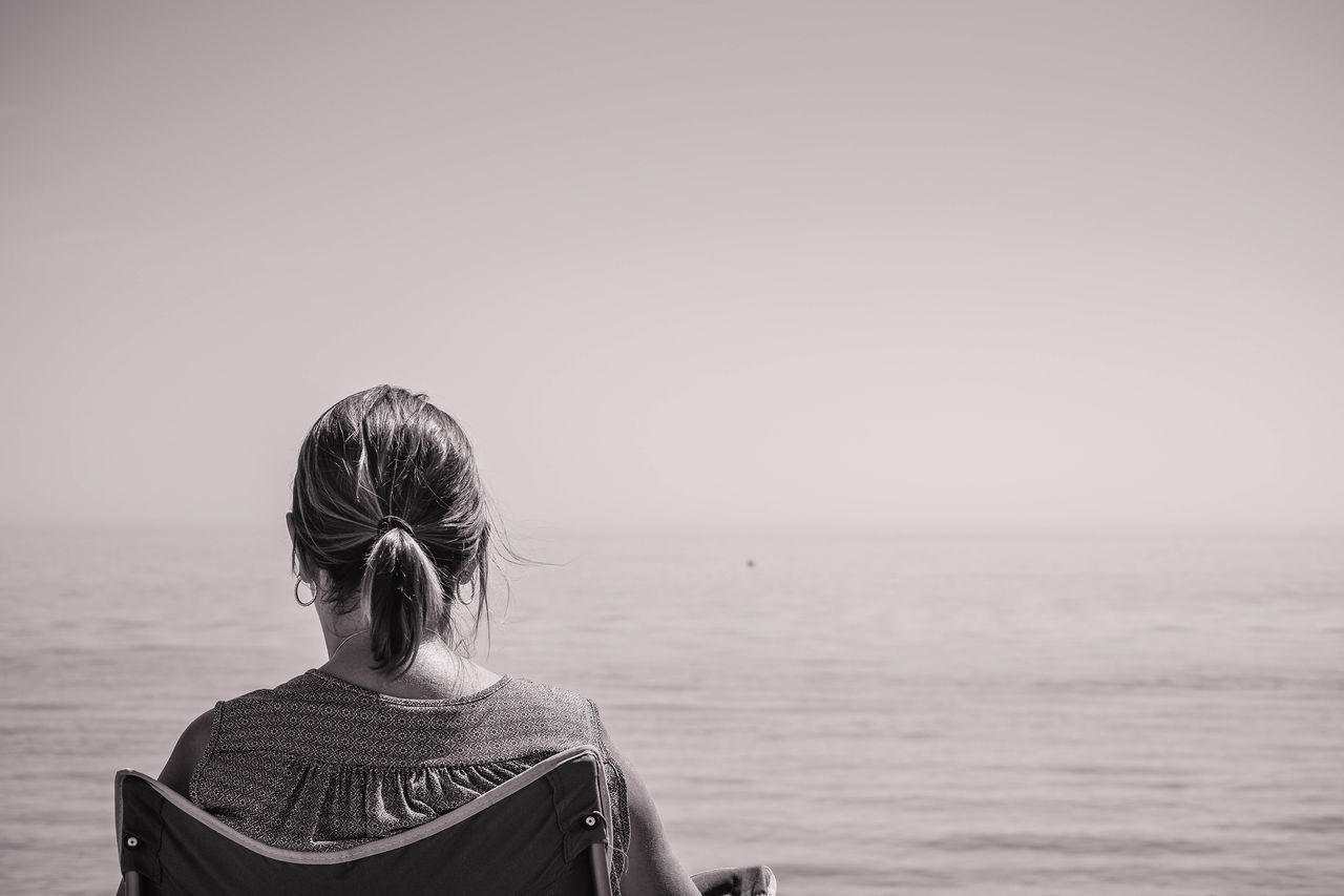 REAR VIEW OF WOMAN AGAINST SEA AGAINST SKY