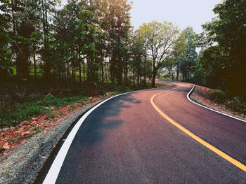 Empty road amidst trees in forest