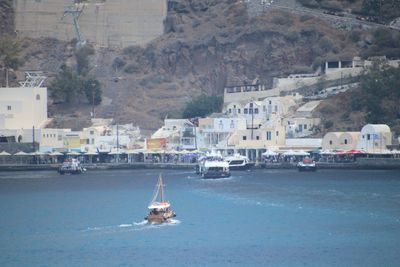 Sailboats in sea by buildings in city