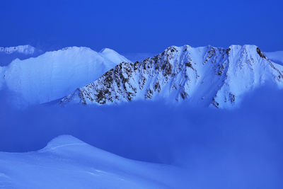 Scenic view of snowcapped mountains against clear blue sky