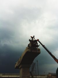 Low angle view of man working at construction site against sky