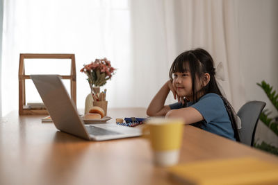 Smiling girl watching movie in laptop at home