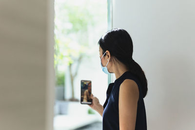 Side view of woman using mobile phone