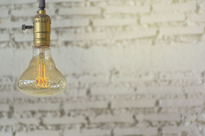 Close-up of light bulb against wall