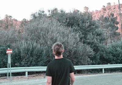 Rear view of man standing on country road