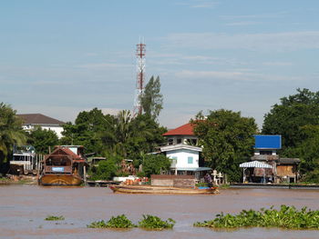 Houses by trees and buildings against sky