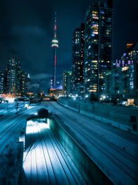 Illuminated modern buildings in city against sky at night toronto cn tower