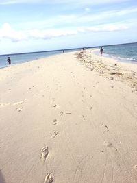 People at beach against sky