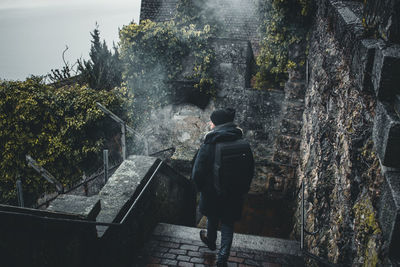 Rear view of man walking by building