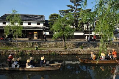 People in front of building against clear sky