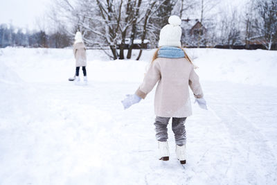 Rear view of women walking on snow