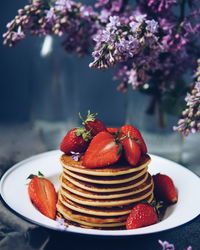 Stack of pancakes with strawberries on table