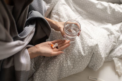 High angle view of person holding hands on bed