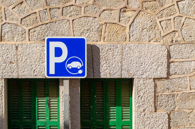 Low angle view of information sign on wall