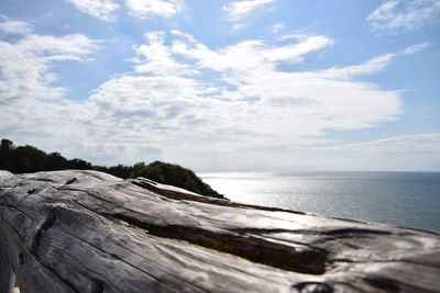 Close-up of wood by sea against sky