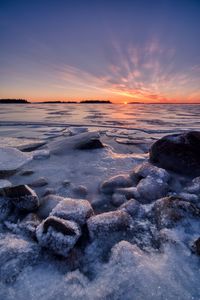 Scenic view of frozen sea against sky during sunset