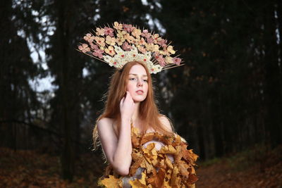 Young woman standing by flower tree