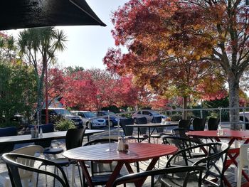 Empty chairs and tables at sidewalk cafe