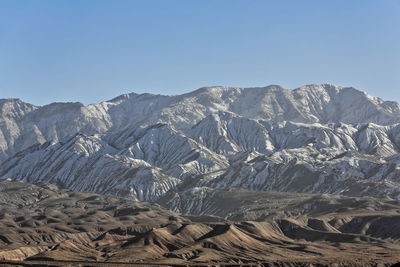 Aerial view of snowcapped mountains against clear sky