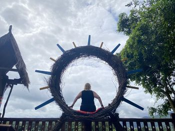 Rear view of woman sitting against sky