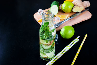 Mojito in bottle with ingredients in black background