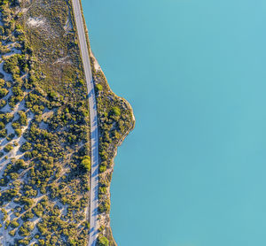Spain, balearic islands, formentera, drone view of empty road stretching along turquoise shore