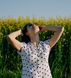 Young woman standing against plants