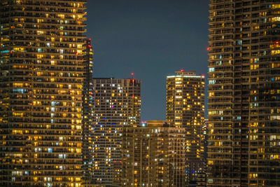 Illuminated buildings against sky at night