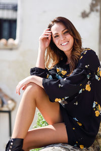 Portrait of smiling young woman sitting outdoors