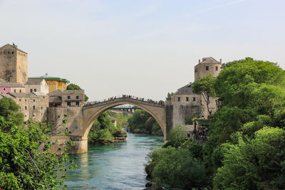 Arch bridge over river against sky