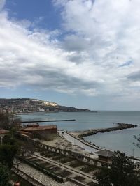 High angle view of city by sea against sky