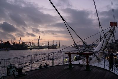 Sailboats on pier at harbor against sky