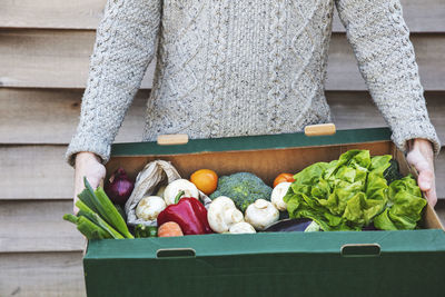 Midsection of woman holding food on table