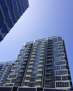 Low angle view of modern building against clear blue sky