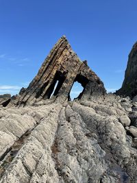 Low angle view of rock formation against blue sky