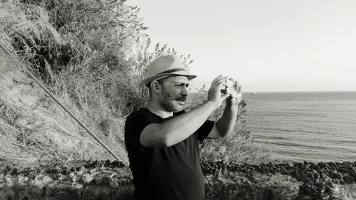 Man standing by sea against sky