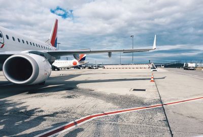 Airplane on airport runway against sky