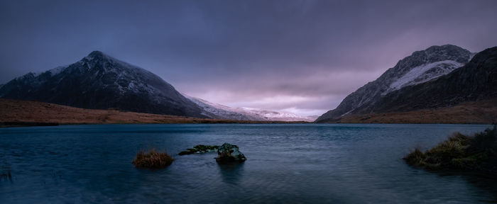 Scenic view of lake by mountains against sky