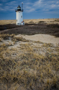 Lighthouse on land against sky