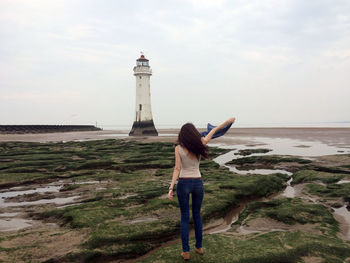 Full length of man standing on beach by sea against sky