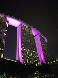 Low angle view of illuminated skyscraper against sky at night