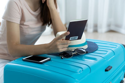 Midsection of woman using smart phone on table