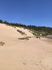 Scenic view of desert against clear blue sky