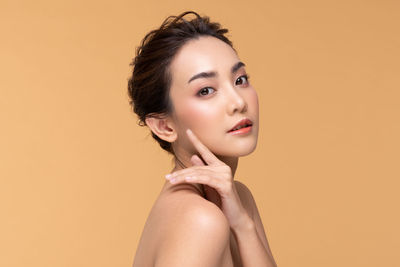 Portrait of young woman against gray background