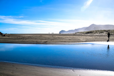 Scenic view of beach against blue sky