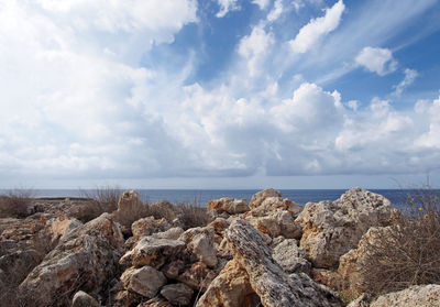 Rocks by sea against sky