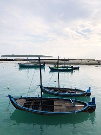 Boat moored in sea against sky