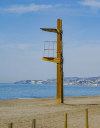 Lifeguard hut on beach against sky