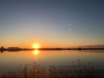 Scenic view of lake against sky during sunset