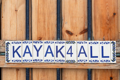 Close-up of warning sign on wooden plank